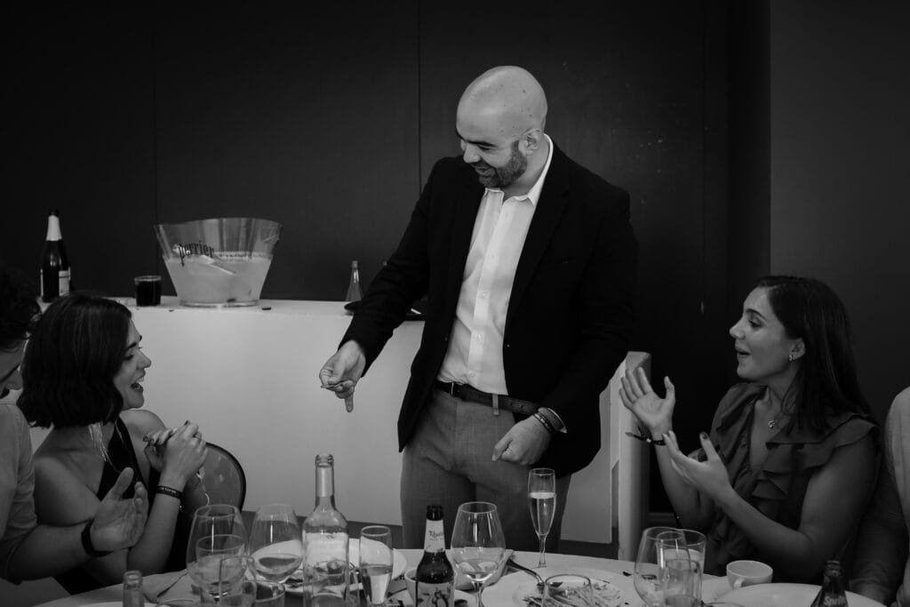 Invitados riéndose y aplaudiendo durante un juego de magia de cerca