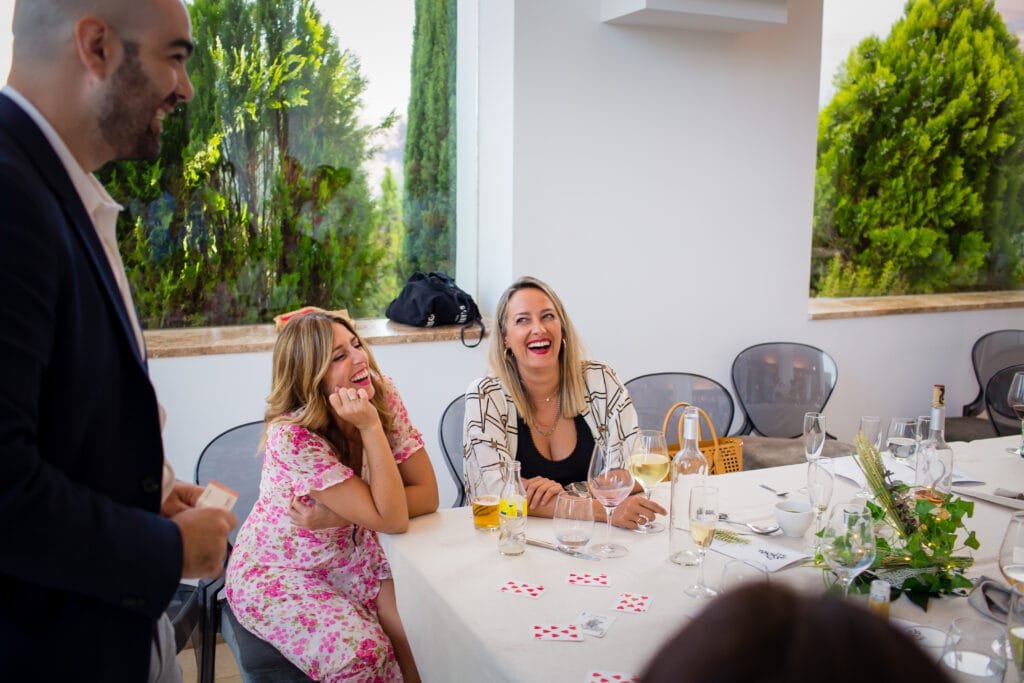 Magia con cartas para dos invitadas sentadas a la mesa, a un palmo de sus manos